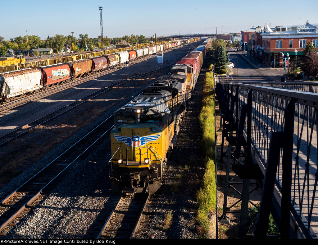 UP 8427 leads and eastbound manifest freight under the pedestrian overpass in Laramie